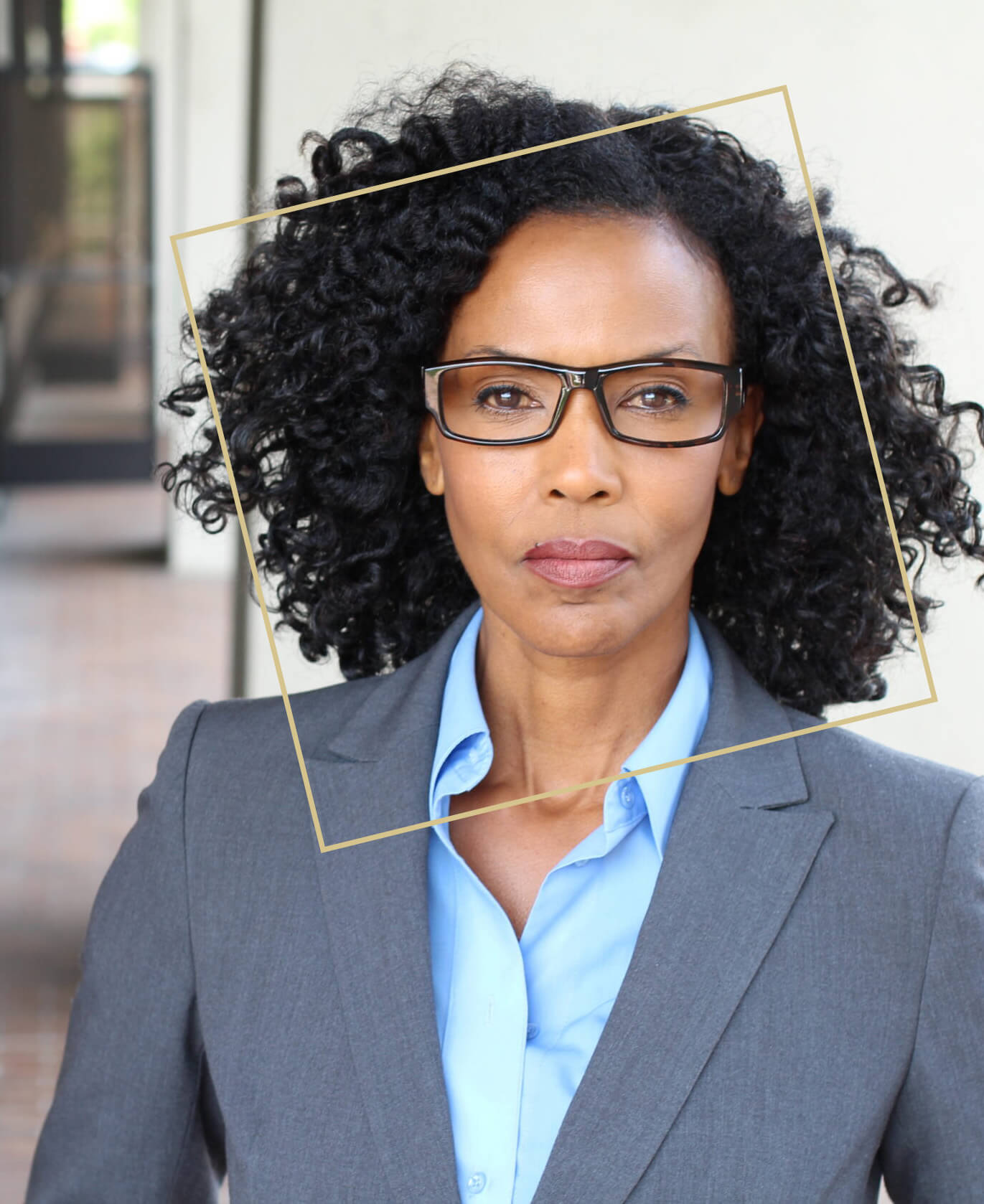 Black business woman with glasses in a gray suit